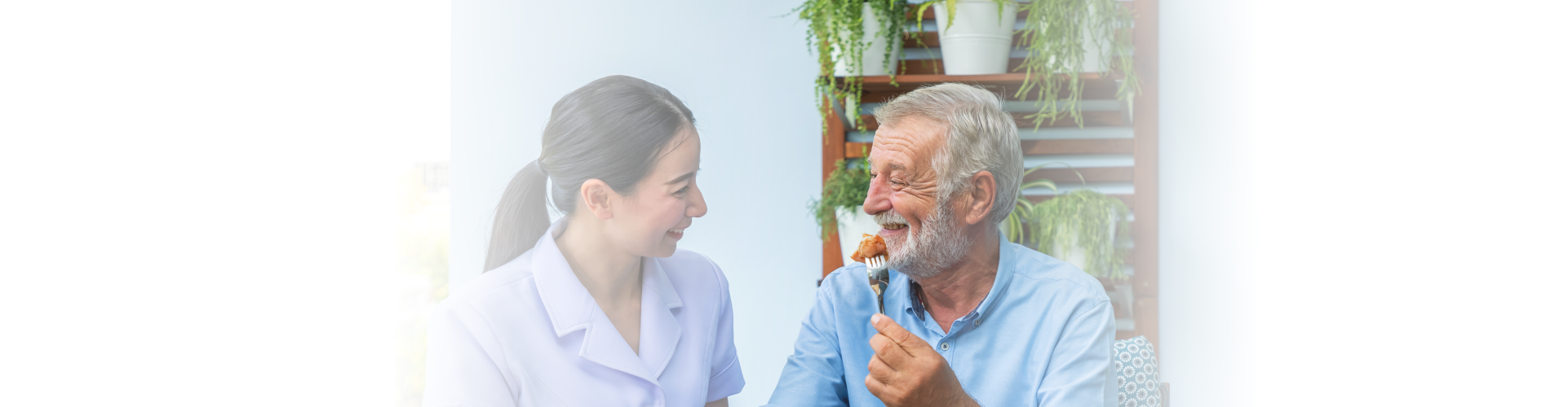 caregiver assist elderly senior man to eat breakfast at home