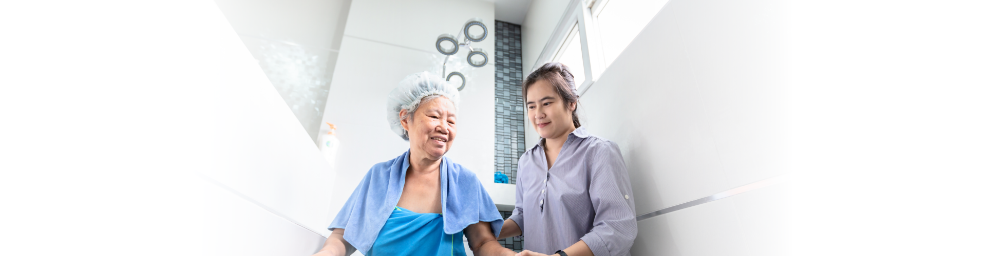 female care assistant service help support senior woman taking shower in bathroom